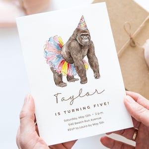Puede incluir: Una tarjeta de invitación blanca con una ilustración de acuarela de un gorila con un gorro de fiesta y un tutú colorido. El texto dice "¡Taylor cumple cinco años!" con detalles del evento.