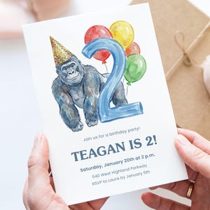 May include: A birthday party invitation featuring a watercolor illustration of a gorilla wearing a party hat and holding a blue number 2 balloon. The invitation reads "TEAGAN IS 2!" with party details.