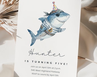 May include: A white invitation card featuring a watercolor illustration of a shark wearing a pirate hat and striped shirt. The text reads "Hunter is turning five!" with event details below. The shark is blue, gray, and white.