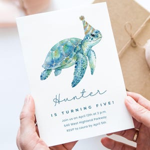 Puede incluir: Una invitación de cumpleaños con una ilustración de acuarela de una tortuga marina azul y verde con un gorro de fiesta dorado. La invitación dice "¡Hunter cumple cinco años!" e incluye detalles del evento.