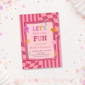 May include: A rectangular birthday invitation card featuring a pink and red checkered background. The center text reads LET'S have some FUN, JOIN US TO CELEBRATE, Amelie is turning 6!, NOVEMBER 23, 4:00-7:00PM, AMELIE'S HOUSE, 3333 BIRTHDAY AV, ORANGE COUNTRY, CA, RSVP TO AMANDA AT 123-456-7890. It includes illustrations of a star, heart, flower, disco ball, and smiley face.