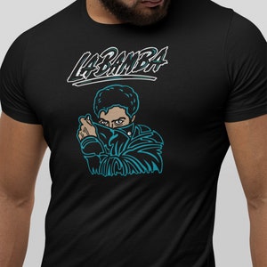 May include: Black t-shirt with a teal graphic of a man wearing a bandana with the text "LA BAMBA" above the graphic.