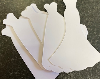 May include: Five white paper dress shapes, cut out and ready for crafting.