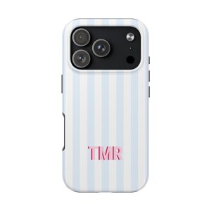 May include: A smartphone case featuring a vertical light blue and white striped pattern. The back of the case displays the letters TMR in a bold pink font centered near the bottom. The camera module area is black with three circular lenses.