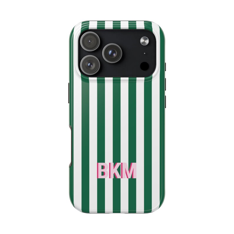 May include: A smartphone case featuring a vertical striped pattern in dark green and white. The back of the case displays the letters BKM in a light pink font centered near the bottom. The camera cutout area is black with three circular lenses.