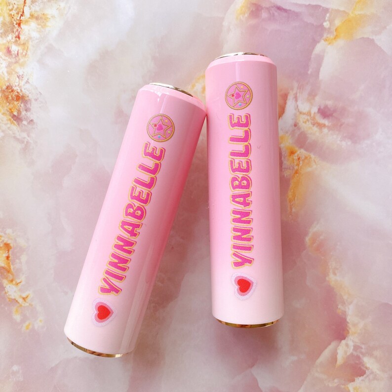 May include: Two pink and white ombre tumblers with gold lids and a pink and white sticker with the text "YINNA BELLE" and a pink heart and star design.
