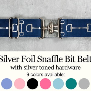 May include: A navy blue belt with silver toned hardware and a snaffle bit design. The belt is available in 9 colors.