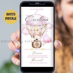 May include: A digital invitation for a baby girl's christening. The invitation features a pink and purple hot air balloon with a teddy bear in the basket. The text on the invitation reads "IL BATTESIMO DI Cristina" and includes the date, time, and location of the event.