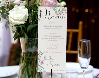 May include: A wedding menu card with floral designs in pink and green. The menu includes a risotto, a filet, and a wedding cake. The card also includes the names Andrea and Sara and the date 08.04.2021.