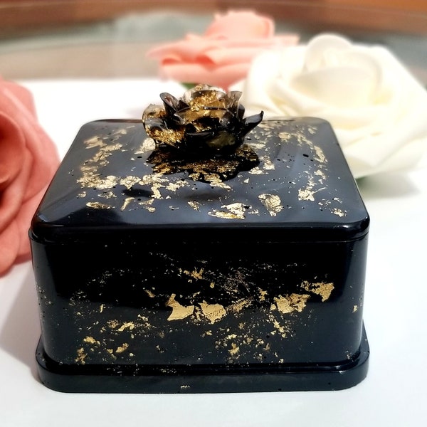 Forbidden Rose Resin Jewelry Box is a black and gold handmade square shaped organizer with a flower on top that can be used for storage