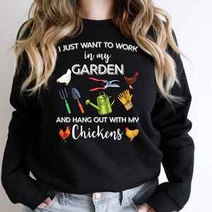 May include: Black sweatshirt with a white graphic print that says "I just want to work in my garden and hang out with my chickens". The graphic also includes a watering can, gardening tools, and chickens.