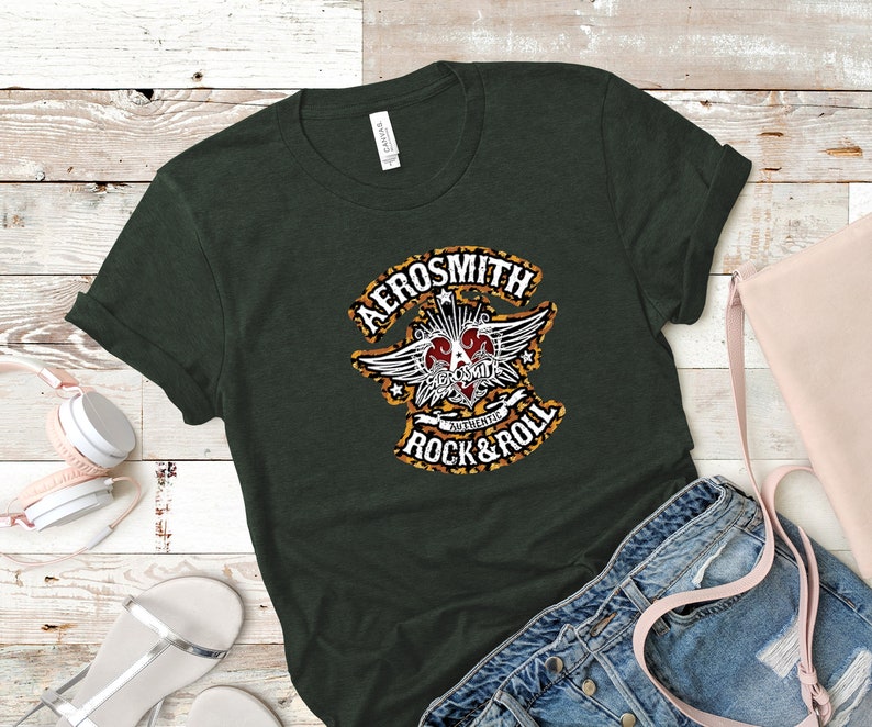 May include: A dark green t-shirt with a leopard print design featuring the text "Aerosmith" and "Authentic Rock & Roll".