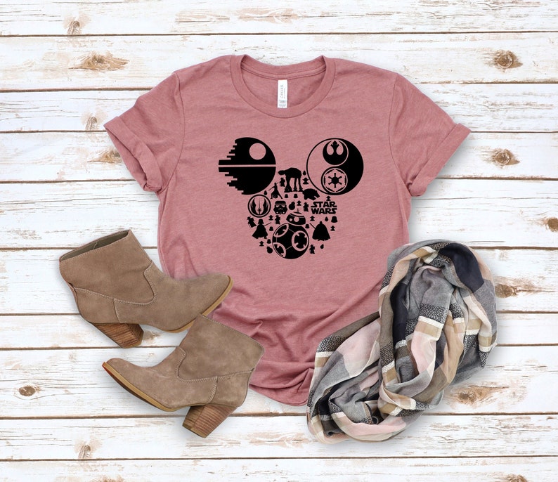 May include: A mauve t-shirt with a black silhouette of Mickey Mouse's head made up of Star Wars characters and the text "Star Wars".