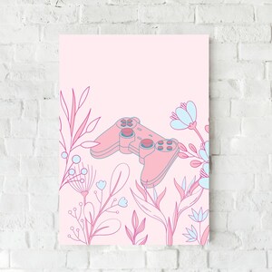 May include: A pink and blue floral art print featuring a video game controller. The controller is in the center of the print, surrounded by pink and blue floral illustrations. The background is a light pink color.