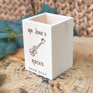 Könnte beinhalten: Ein Bleistifthalter aus Holz mit dem Text "Mr. Jones' Rocks from Billy" und einer Zeichnung einer Gitarre.