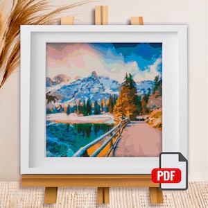 May include: A framed painting of a snowy mountain landscape with a lake and a path leading to a forest. The sky is a vibrant blue with pink and orange clouds.