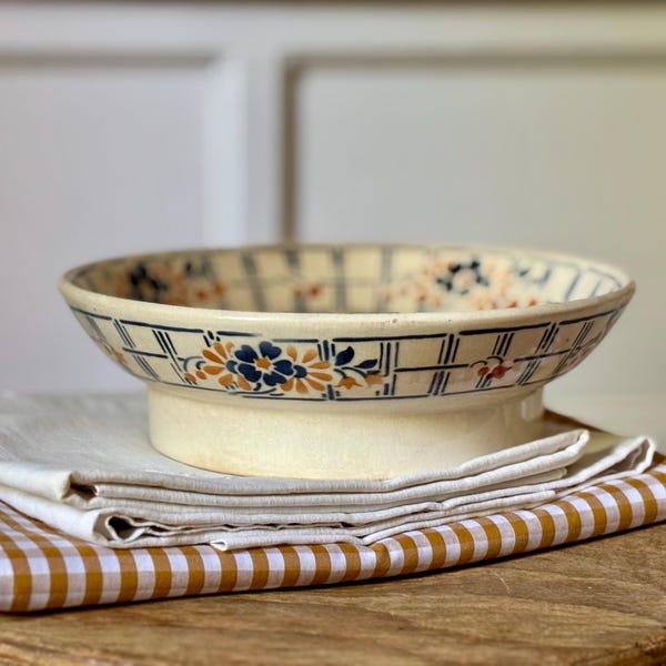 Antike niedrige Obstschale auf kleinem Fuß, aus Eisenton, mit doppelten Friesen und Blumendekor, Blau- und Ockerfarben auf patiniertem Hintergrund, Badonviller.