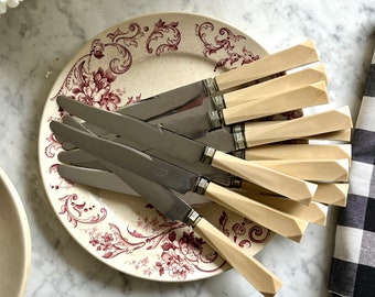 Set de 12 couteaux anciens à manche en Bakélite crème, à virole et forme Art Déco