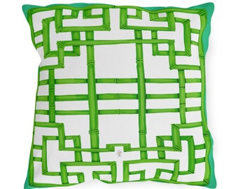 Può includere: Un cuscino quadrato bianco con un motivo a bambù verde. Il cuscino ha un bordo turchese.