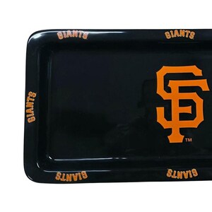 May include: A black rectangular tray with rounded corners. The San Francisco Giants logo in orange is centered on the tray. The word "GIANTS" is printed in orange along the edges of the tray.