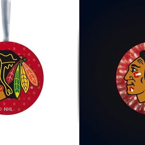 May include: A round, red ornament featuring the Chicago Blackhawks logo. The logo depicts a Native American head in profile with a black headdress and colorful feathers. The ornament has a silver ribbon for hanging and the NHL logo.