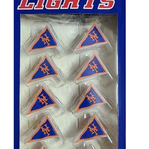 Pode incluir: Pacote de luzes de festa com o logotipo do New York Mets. As luzes têm formato de flâmulas nas cores azul e laranja. A embalagem diz "Sports Collectors Series Party Lights" e inclui 10 luzes em uma corda de 3,05 metros.