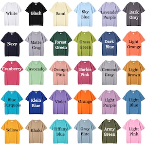 Op de afbeelding: Een tabel met 36 verschillende gekleurde T-shirts met tekstlabels voor elke kleur. De kleuren omvatten wit, zwart, zand, hemelsblauw, lavendelpaars, donkergrijs, marineblauw, matgrijs, bosgroen, grasgroen, donkerblauw, lichtoranje, cranberry, avocado, oranje roze, barbie roze, cement grijs, lichtbruin, blauw turquoise, kleinblauw, violet, oranje, lichtpaars, lichtblauw, geel, kaki, tiffanyblauw, grijsblauw, legergroen en lichtroze.
