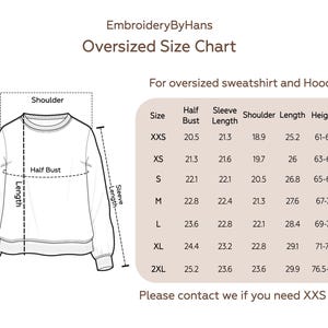 Op de afbeelding: Maattabel voor oversized sweatshirts en hoodies. De tabel toont de maten in inches voor halve borstomvang, mouwlengte, schouderbreedte, lengte en hoogte. De maten omvatten XXS, XS, S, M, L, XL en 2XL.