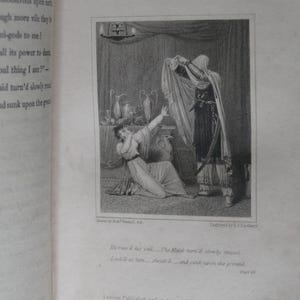 May include: An antique black and white illustration from a book, depicting a scene with two figures. One figure, veiled, holds a cloth, while another, a woman, kneels in distress. The text "THE VEILED PROPHET OF KHORASSAN" is at the top.