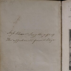 May include: Open book with handwritten inscription: "Miss Eleanor Lung the gift of His affectionate friend Eliza." The right page displays the title "Lalla Rookh" by Thomas Moore, with illustrations.