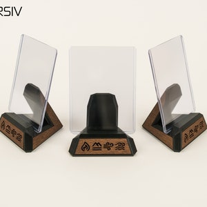 May include: Three clear acrylic card holders on wooden stands with black bases. Each stand has a different symbol carved into the wood: fire, water, and air.