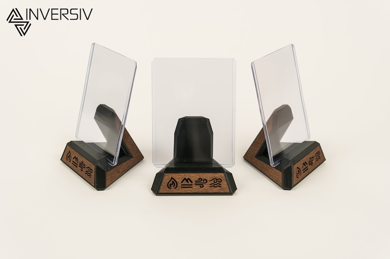 May include: Three clear acrylic card holders on wooden stands with black bases. Each stand has a different symbol carved into the wood: fire, water, and air.