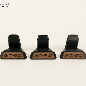 May include: Three black and brown wooden display stands with a geometric design. Each stand has a small wooden plaque with the symbols for fire, earth, air, and water.