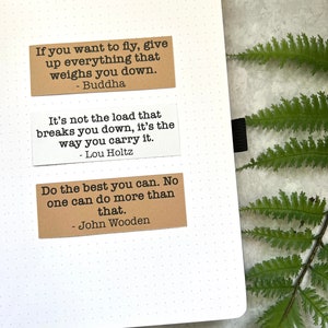 Quotes by various authors in Kraft brown and white sticker paper strips on an A5 dotted journal.