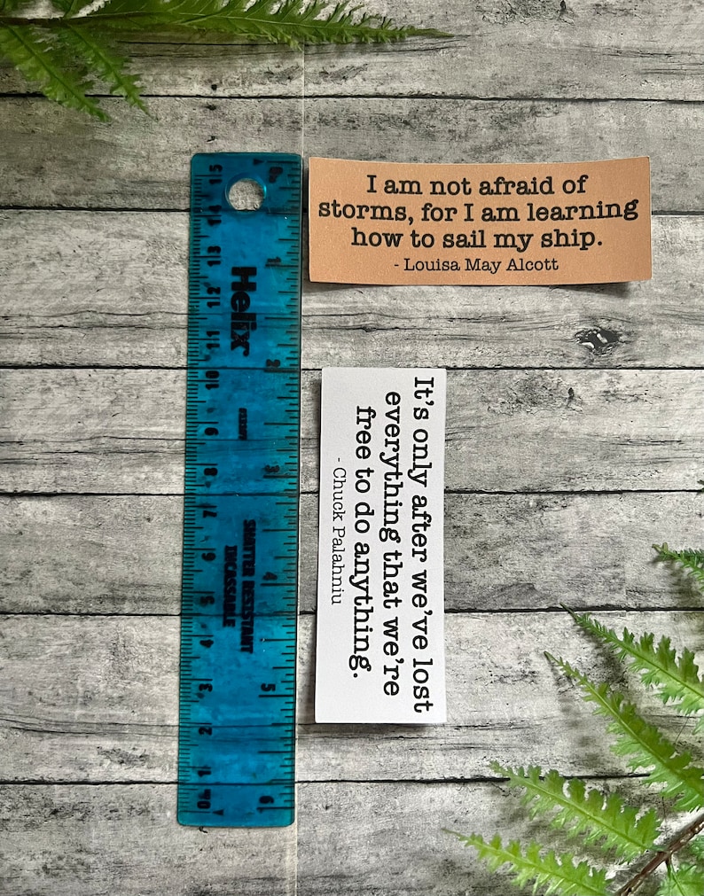 Book quotes in Kraft brown and white sticker paper strips next to a blue ruler that shows they are 1.20 in.(H) X 3.25 in. (W)