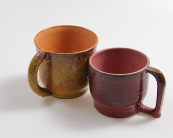 "Tetera" de cerámica para muchas bebidas, naranja y roja, hecha a mano en el torno de alfarero