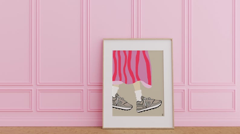 May include: A framed illustration of a person's legs wearing a pink and red striped skirt and gray sneakers. The background is a light brown color.