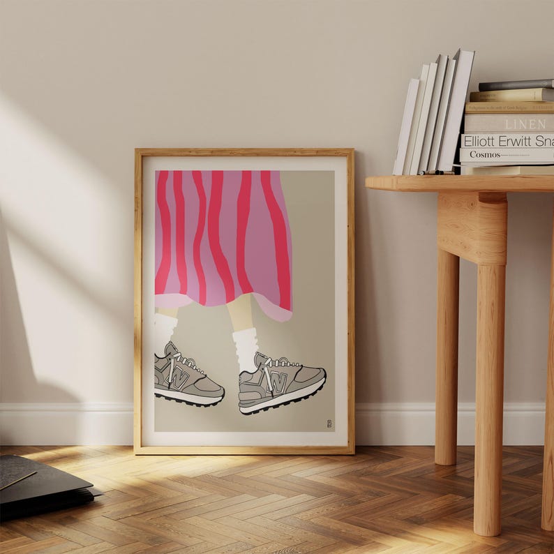 May include: A framed illustration of a person wearing a pink and purple striped skirt and grey sneakers. The person's legs are visible from the knee down.