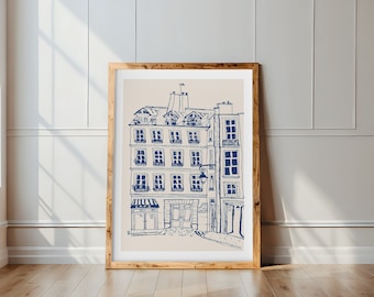 May include: A framed illustration of a Parisian street scene with a cafe and a building with multiple windows. The illustration is drawn in blue ink on a beige background.