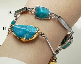 May include: Two turquoise stone bracelets. One bracelet features silver-toned metal links and turquoise stones. The other bracelet has gold-toned metal and turquoise stones. The bracelets are worn on a wrist.