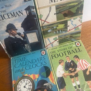 May include: A collection of vintage Ladybird books. Titles include "The Policeman at Work," "Understanding Maps," "Time, Calendars and Clocks," and "The Story of Football." The books have colourful illustrations and text, with a retro design.
