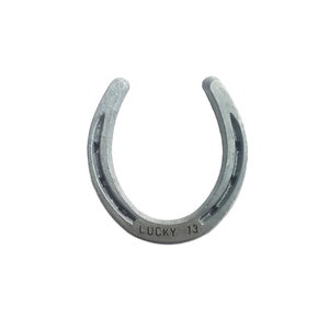 May include: A silver horseshoe with the words "LUCKY 13" engraved on the bottom.