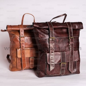Peut inclure: Deux sacs à dos en cuir avec des bretelles et des boucles réglables. Le sac à dos de gauche est brun et beige, tandis que le sac à dos de droite est brun.
