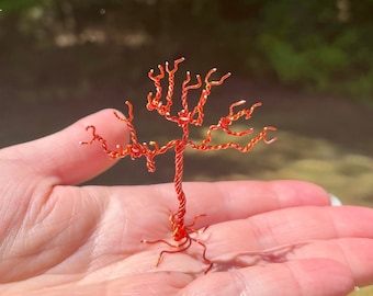 Scultura di albero avvolto in filo arancione, arte da tavolo