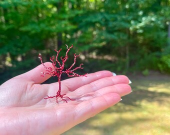 Escultura de árvore envolta em arame vermelho, arte para mesa