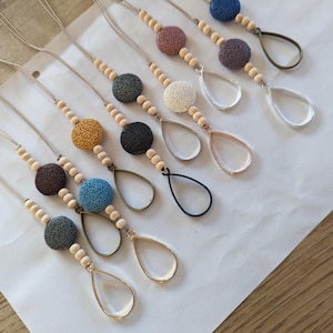 May include: A set of ten necklaces featuring lava rock beads and a teardrop-shaped pendant. The necklaces are crafted from natural materials and come in a range of colours, including black, brown, blue, white, and pink.