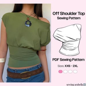 Könnte beinhalten: Ein olivgrünes Off-Shoulder-Top mit braunem Gürtel und blauer Jeans. Das Bild zeigt auch ein PDF-Schnittmuster für das Top, mit Größen von XXS bis 2XL. Der Text "Off Shoulder Top Sewing Pattern" wird angezeigt.