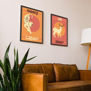 May include: Two framed prints with a retro design. The left print features a tiger with the text "easy tiger". The right print features a deer with the text "oh deer".