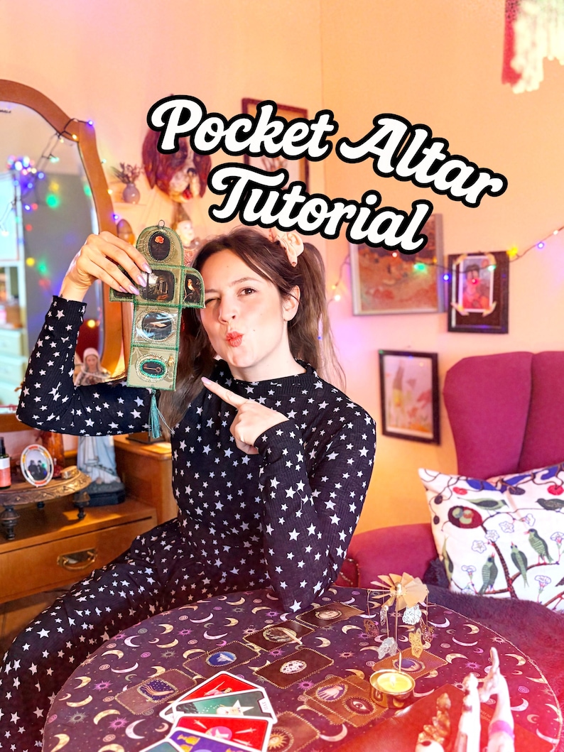 K&ouml;nnte beinhalten: Ein schwarzer Overall mit wei&szlig;en Sternen und dem Text "Pocket Altar Tutorial". Die Person h&auml;lt einen kleinen, gr&uuml;nen und goldenen Taschenaltar. Ein Tisch mit Tarotkarten und Kerzen befindet sich im Vordergrund.