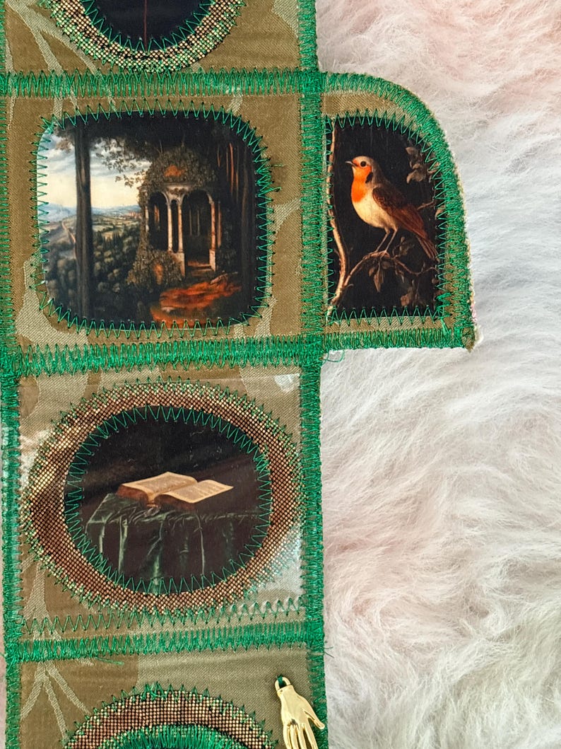 K&ouml;nnte beinhalten: Ein handgefertigtes Textilkunstwerk mit Patchwork-Design. Es zeigt kleine, gerahmte Bilder eines Vogels, eines Pavillons und eines offenen Buches. Das St&uuml;ck ist mit gr&uuml;nen N&auml;hten und goldenen Akzenten versehen, vor einem strukturierten Hintergrund.